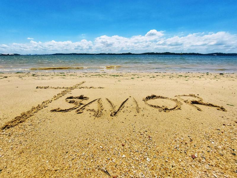 savior written in the sand on a beach referring to jesus